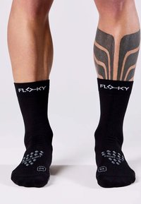 Calzini neri fino alla caviglia con il marchio "FLEXKY", caratterizzati da suole testurizzate con modelli di trazione per il piede sinistro e destro.