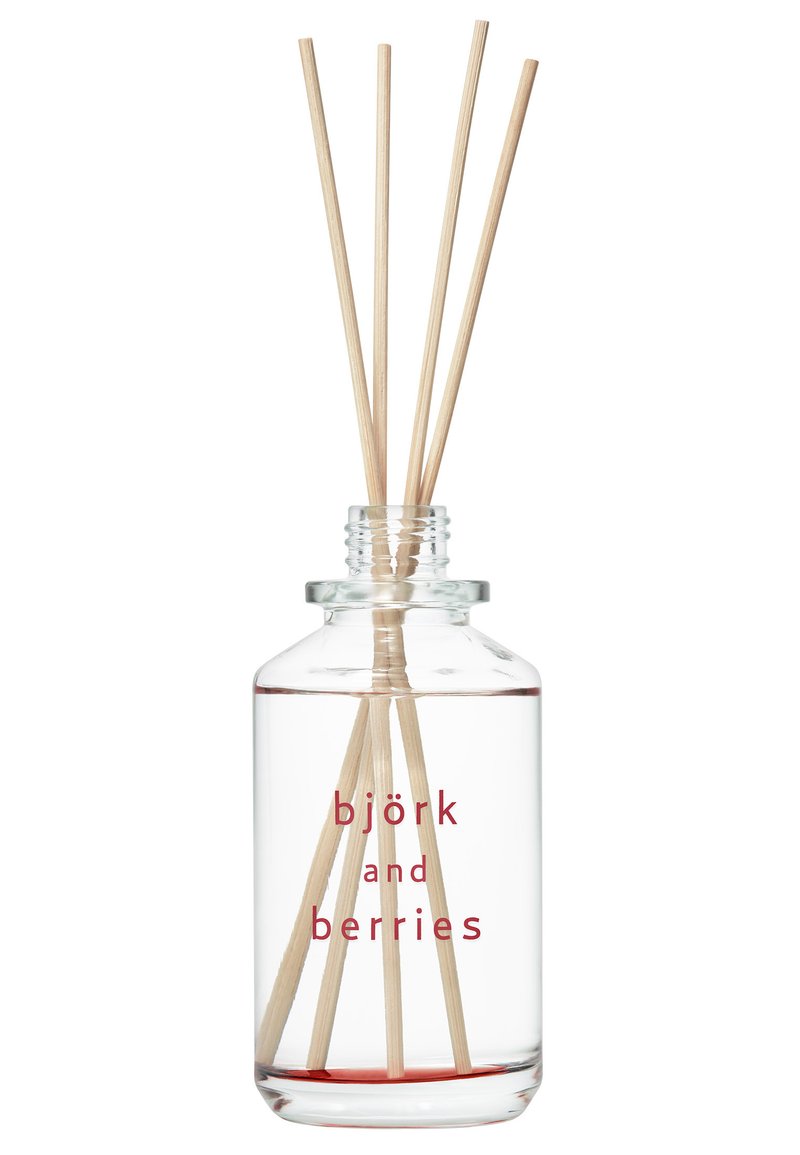Klarer Glasdiffusor mit roßer Flüssigkeit, fünf Holzstäbchen und "Björk und Beeren" in fettem Rot auf der Vorderseite bedruckt.
