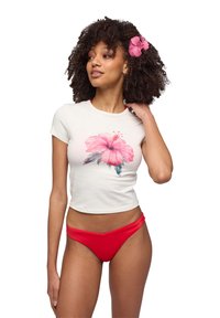 T-shirt bianco corto con grande stampa di un fiore hibiscus rosa. Abbinato a slip di bikini rossi. Tessuto liscio; maniche corte.