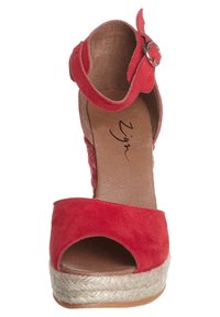 Sandales plateformes en daim rouge avec bout ouvert, brides de cheville dotées d'une boucle ronde et talon compensé en jute. Semelle intérieure en cuir lisse.