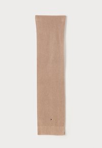 Calza in maglia beige con estremità a costine, dotata di una piccola etichetta con logo vicino al fondo. Texture morbida e forma allungata per garantire calore.