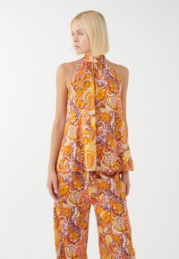 Kleurvolle haltertop met een ingewikkeld bloemmotief in oranje, geel en roze op lichte stof, met een gestrikte halslijn.