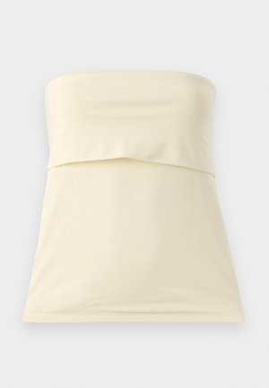 Haut sans bretelles crème en tissu lisse et extensible. Présente un design plié au niveau de la poitrine et un ourlet droit. Style simple et minimaliste.