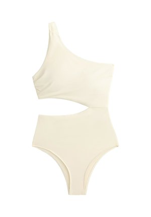Maillot de bain une pièce ivoire asymétrique avec découpe au niveau de la taille et jambes hautes.