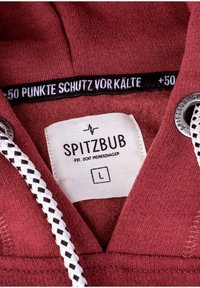 Bordeauxfarbener Kapuzenpullover mit Fleece-Innenfutter, ausgestattet mit einer weißen Kordel mit schwarzen Akzenten, einem Etikett mit der Aufschrift "SPITZBUB" und einem Kälteschutzschild.