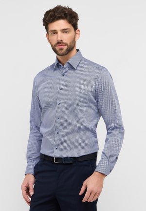 Heren overhemden met knopen in marineblauw en wit, met een geometrisch patroon, een klassieke kraag, lange mouwen en blauwe knopen. Draag ze met donkere pantalons.