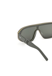 Šedé sluneční brýle s tmavými skly, štíhlý rám s tenkým zlatým akcentem a rovné nožičky s texturovaným povrchem pro lepší úchop.