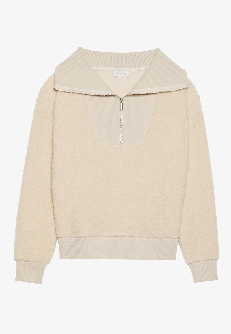 Beiger Fleece-Pullover mit Reißverschlusskragen und gerippten Akzenten. Verfügt über eine strukturierte Oberfläche und einen lockeren Schnitt, geeignet für die Freizeit.
