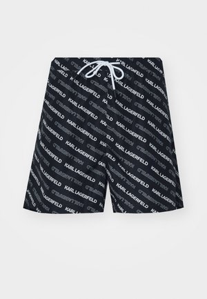 Morski plavalni šortiji z ponavljajočim se belim napisom "KARL LAGERFELD", elastičnim pasom in belim vrvico. Material deluje gladko in lahkotno.