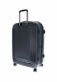 Valigia rigida da cabina di colore grigio scuro, con un design rettangolare elegante, texture rigata, maniglia retrattile e quattro ruote per la mobilità.