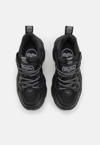 Black athletic shoes with a mesh and synthetic upper. Features include thick soles, reflective laces, and branded accents on tongue and heel.
