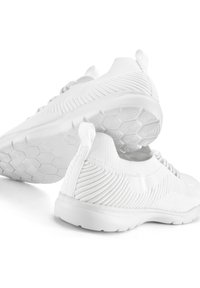 Witte sport schoenen met een textuur breimand, vetersluiting en een flexibele zool met een hexagonaal patroon aan de onderkant.