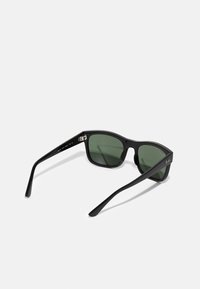 Ochelari de soare dreptunghiulari negri cu lentile verzi, având un cadru din plastic elegant și accente metalice pe laterale.