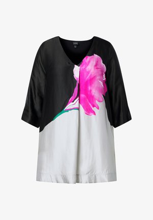 Sort-hvid bluse med trekvartlange ærmer og stort lyserødt blomsterprint foran.