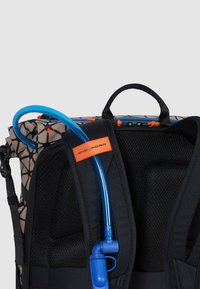 Zaino nero e marrone con una texture a rete, dotato di un tubo di idratazione blu e di un'etichetta arancione di accento sulla cinghia.