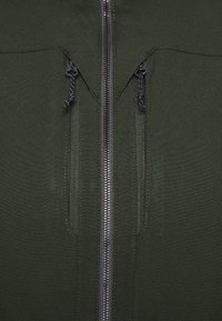Giacca verde oliva con due tasche con zip, una zip centrale e un tessuto resistente per una maggiore resistenza alle intemperie.
