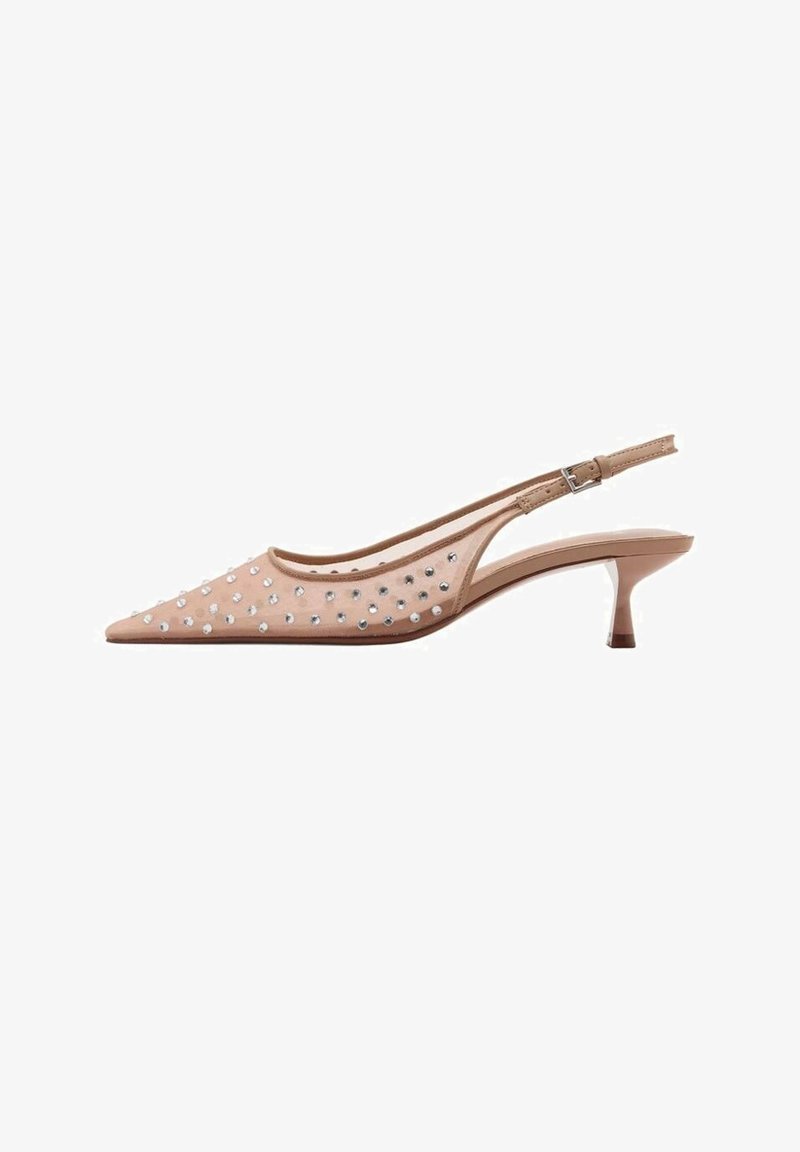 Chaussure slingback beige à bout pointu avec un petit talon kitten, tige transparente ornée de petits clous argentés et bride réglable avec boucle.