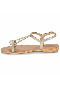 Platt sandal med en beige lädersula, med korsande metallremdesign, justerbar vristrem och slät textur.