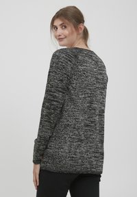 Black and gray sweater with a textured, marled pattern, crew neckline, long sleeves, and slight side slits at the hem.