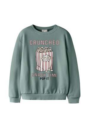 Sudadera verde con gráfico de bolsa de palomitas y texto rosa que dice "CRUNCHED SNACK TIME POP IT" en la parte delantera.