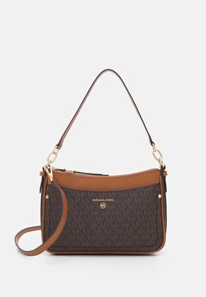 Brązowa i beżowa torebka Michael Kors z podwójnymi paskami, złotym logo i wzorem monogramu na jednolitym jasnym tle.