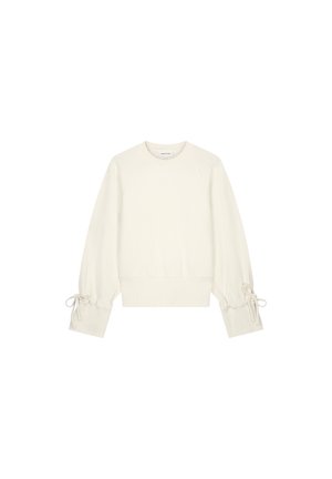 Witte lange mouwen sweatshirt met ronde hals, geribde boorden en zoom, en strikjes op elke mouw nabij de polsen.
