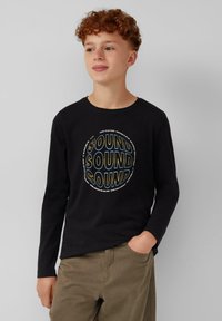 Zwart langarm t-shirt met een ronde graphic waarop het woord "SOUND" herhaald wordt in vettige letters. Casual pasvorm met een ronde halslijn.