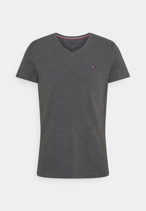 T-shirt à manches courtes gris foncé avec col en V, petit logo rouge, blanc et bleu sur la poitrine gauche et détail rayé au niveau du col.