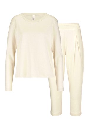 Top a maniche lunghe crema con scollatura rotonda e pantaloni slim-fit coordinati, entrambi in tessuto morbido e liscio con vita elastica.