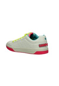 Sneaker bianco con design perforato, lacci gialli accesi e suola rosa. "SHOP" ricamato sul tallone, fodera turchese.