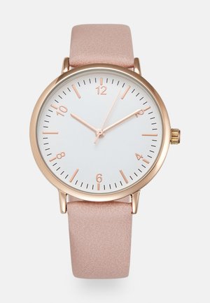 Round white watch face with rose gold accents, featuring a light pink leather strap, minimalist design, and clear numeric markers.