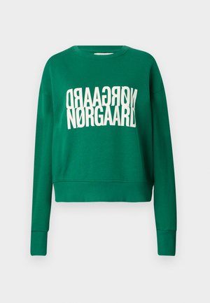 Roheline lühikeste varrukatega sveder pehmest kangast, mille esiküljel on valge, vertikaalselt suunatud tekst "Nørgaard". Pikad varrukad ribiga mansettidega.