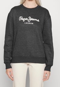 Felpa grigia scura realizzata in tessuto morbido. Presenta polsini e orlo a coste; "Pepe Jeans London" ricamato in bianco sul petto.