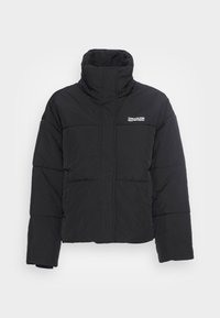 Svart puffjacka med hög krage, kviltad design och liten logotyp på bröstet. Har långa ärmar och en cropped längd.