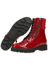 Bottes cheville rouges brillantes à lacets avec fermeture éclair latérale, col rembourré, semelle en caoutchouc noire et motif de crampons détaillé sur la semelle extérieure.