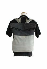 Zaino grigio e nero con design a roll-top, dotato di una tasca frontale con zip, spallacci regolabili e una superficie in tessuto testurizzato.