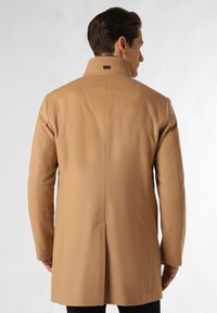 Beige uldfrakke med høj krave, lige snit og en enkelt rygslids. Glat tekstur med en subtil glans og minimale hardware detaljer.