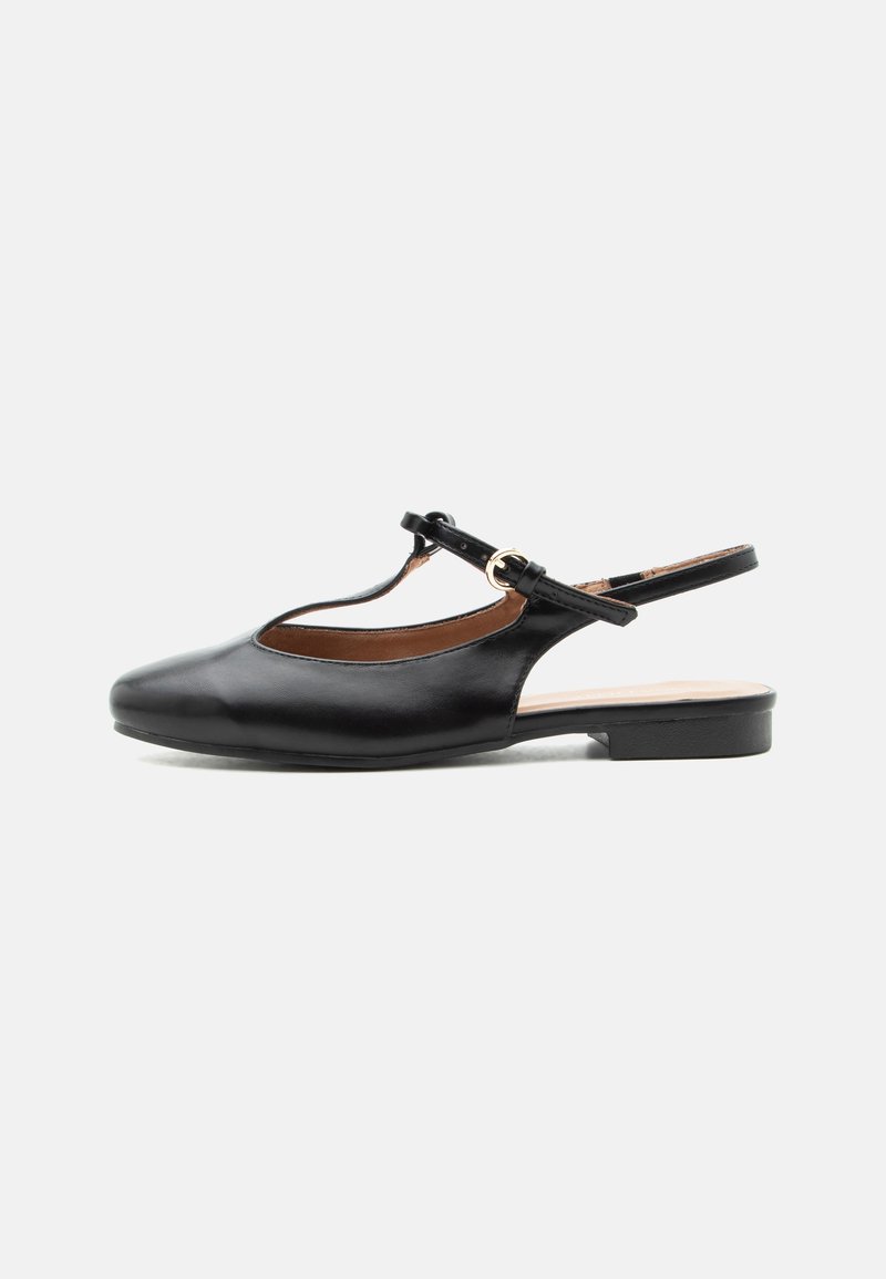 Μαύρο δερμάτινο flat slingback παπούτσι με T-λαιμόκοψη και χρυσή αγκράφα σε ουδέτερο φόντο.