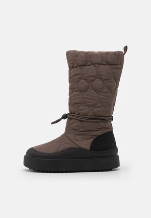 Stivale marrone imbottito fino al ginocchio con punta arrotondata, suola in gomma nera e cordoncino regolabile nella parte superiore. Tessuto texturizzato e motivo cucito.