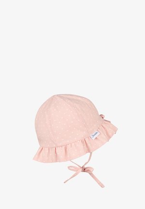Soft pink baby hat with white polka dots, ruffled brim, and tie straps, featuring a small fabric brand label on the side.