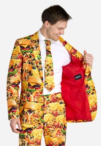 Traje con estampado de comida en una vibrante combinación de colores amarillos, rojos y naranjas, que presenta imágenes de hamburguesas, papas fritas y bocadillos. Forro interior rojo.