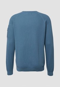 Pull en tricot bleu à manches longues avec poignets et ourlet côtelés, doté d'une petite poche sur la partie supérieure de la manche gauche.