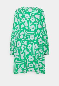 Vestito verde con un audace motivo floreale bianco, maniche lunghe, vita arricciata e una vestibilità ampia. Realizzato in tessuto leggero.