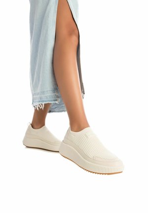 Zapatillas sin cordones color beige con una parte superior de punto texturizado y una suela de goma gruesa, con un diseño estriado y un acolchado suave.