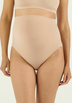 Frau trägt hautfarbene Shapewear-Slip mit hoher Taille und passendes Crop-Top, zeigt eine glatte Passform und Abdeckung an Hüften und Bauch.