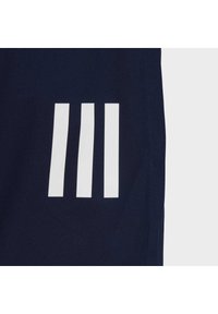 Marinefarbene Stoffshorts mit weißem Dreistreifen-Logo an der Seite, mit einer glatten Textur und tailliertem Schnitt.