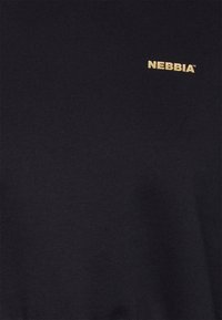 T-shirt noir en coton doux, avec un logo "NEBBIA" brodé en or sur la poitrine. Texture lisse, coupe classique et design minimaliste.
