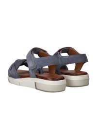 Grijze suède sandalen met een gedraaide ontwerpen aan de voorkant, verstelbare banden en een witte dikke zool. Gestructureerde bruine binnenvoering.