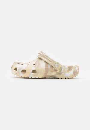Sabot beige et blanc tie-dye à enfiler avec des trous de ventilation, semelle texturée et bride de talon ajustable, vu de côté.