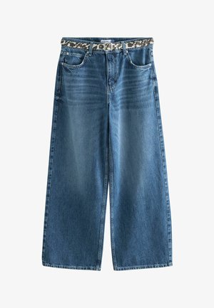 Leveälahkeiset siniset farkut, joissa on etutaskut ja leopardi-kuvioitu vyö pujotettuna vyölenkkien läpi.